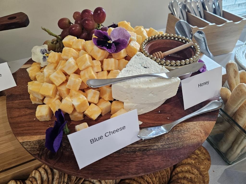 Elegant charcuterie board with cheese, grapes, and flowers