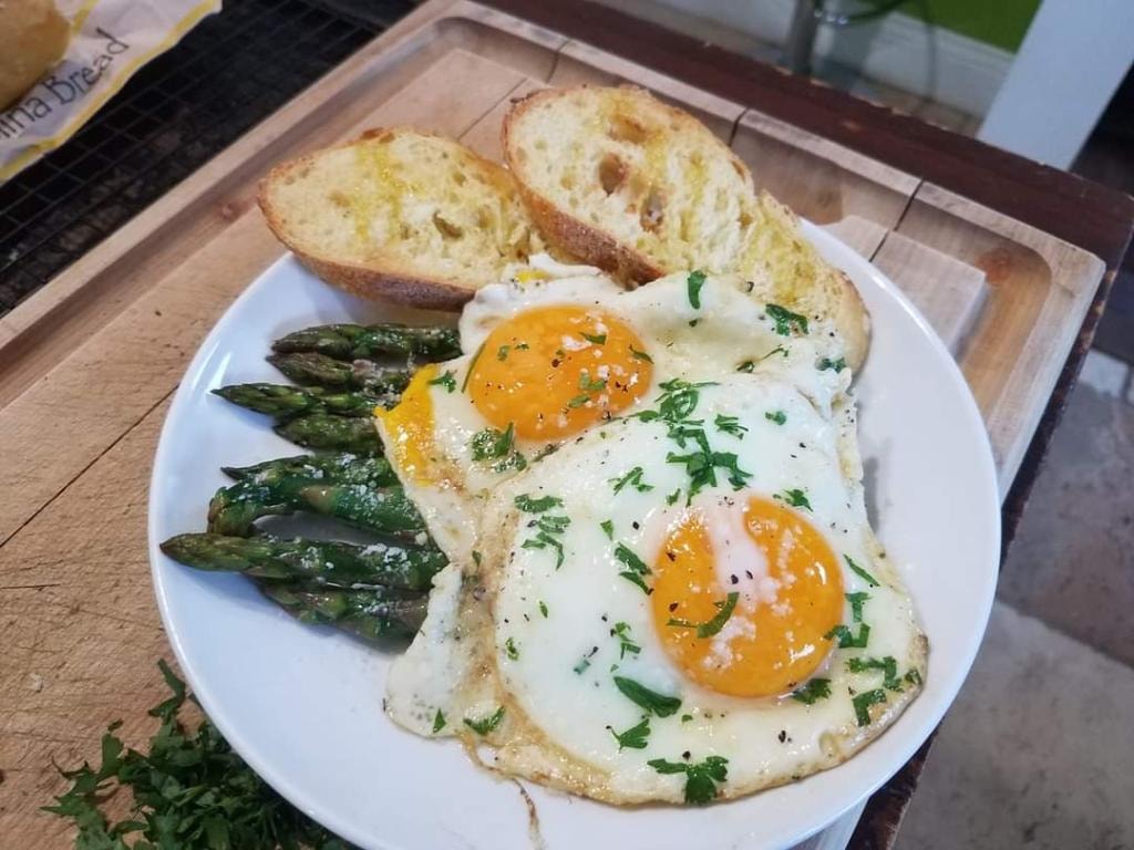Fried eggs, asparagus, and toast breakfast plate