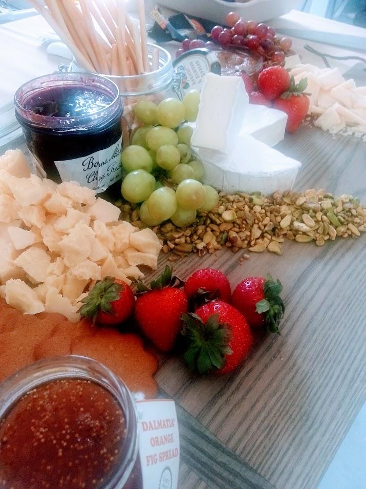 Charcuterie board with fruits, nuts, and spreads