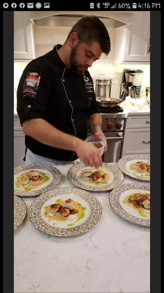 Chef plating scallop dishes in kitchen