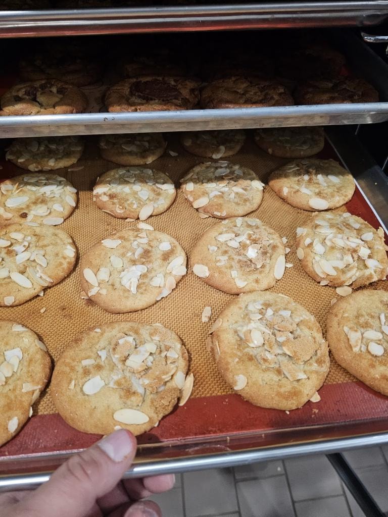 Almond-topped baked pastries on trays