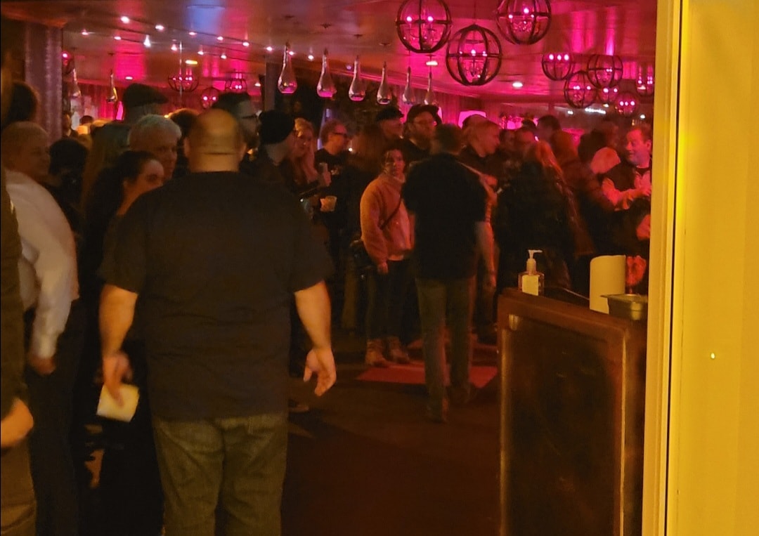Crowded nightclub with pink neon lights