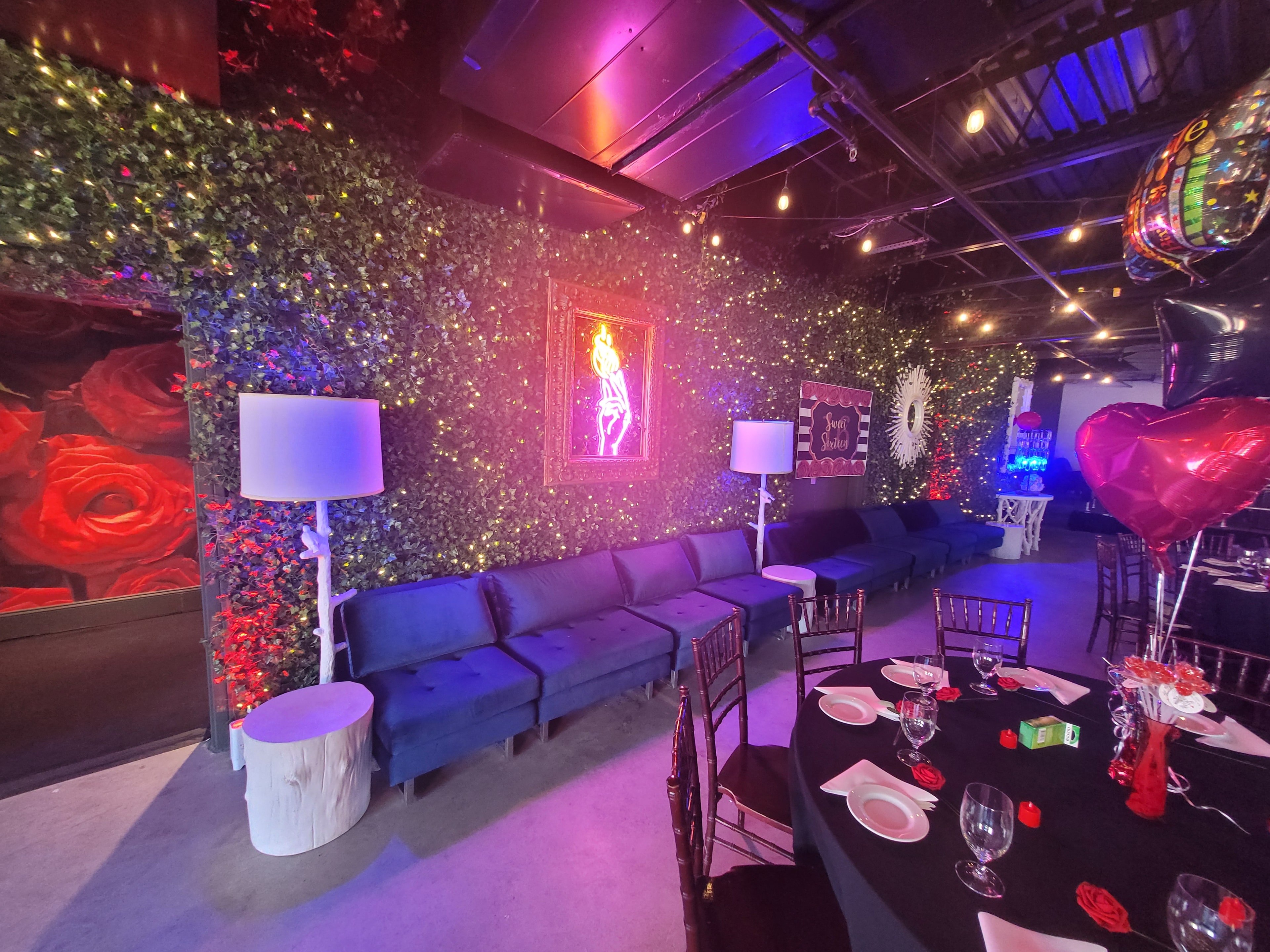 Johnny and June lounge area with blue velvet sofas and neon art
