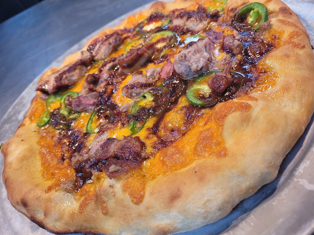 Loaded hot dog with bacon, jalapeños, and cheese