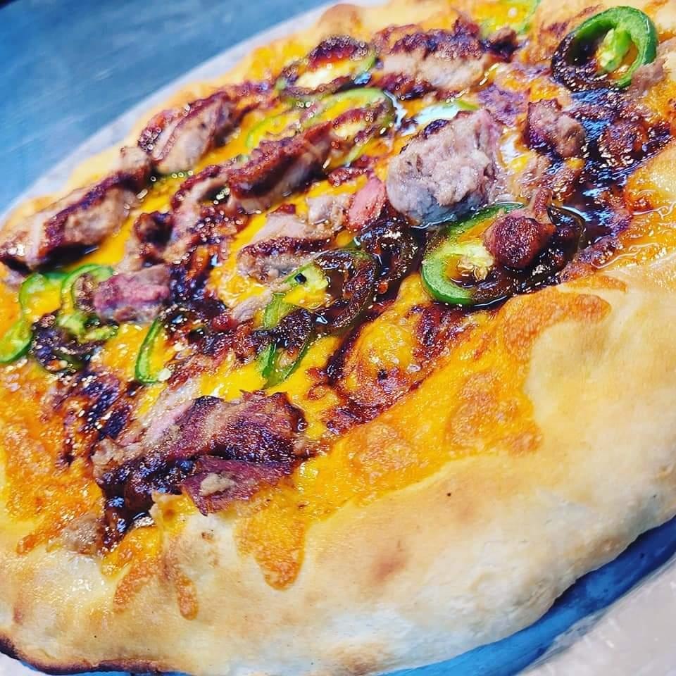 Johnny and June loaded meat and pepper pizza