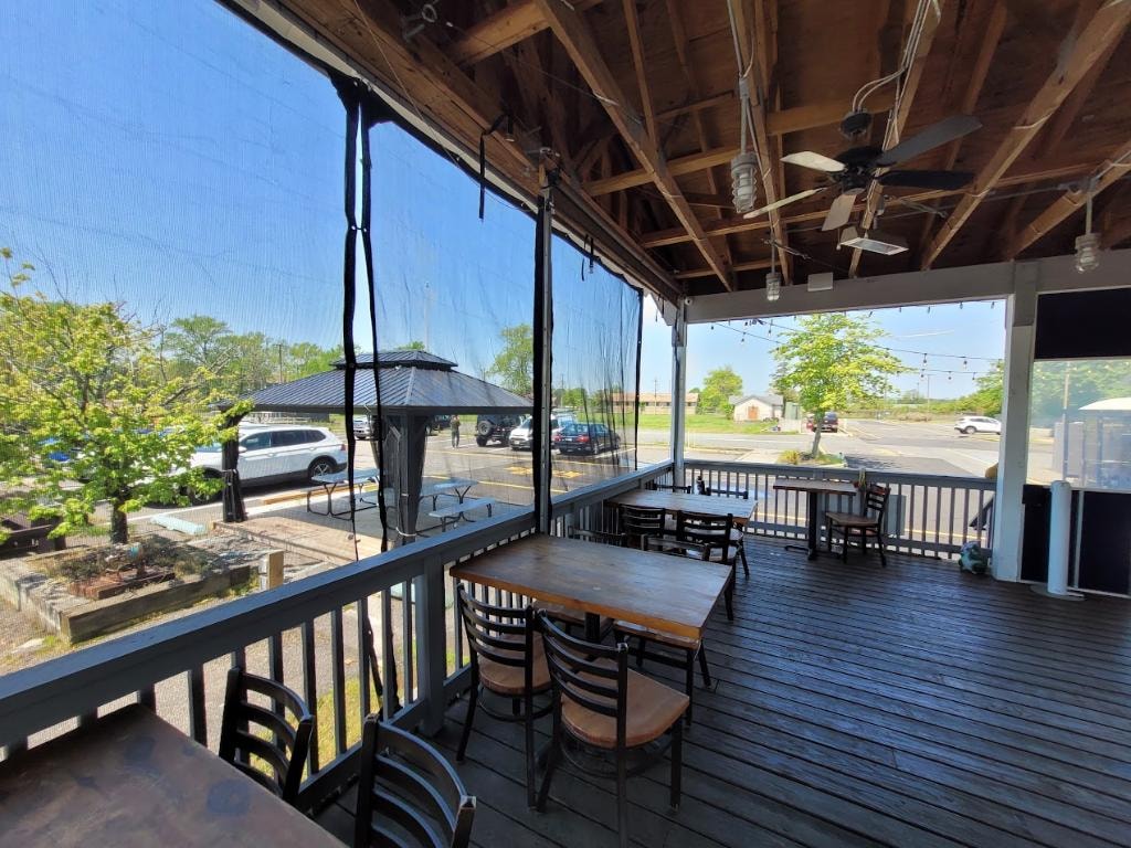 Oceanport Marina screened porch dining overlooking parking and grounds