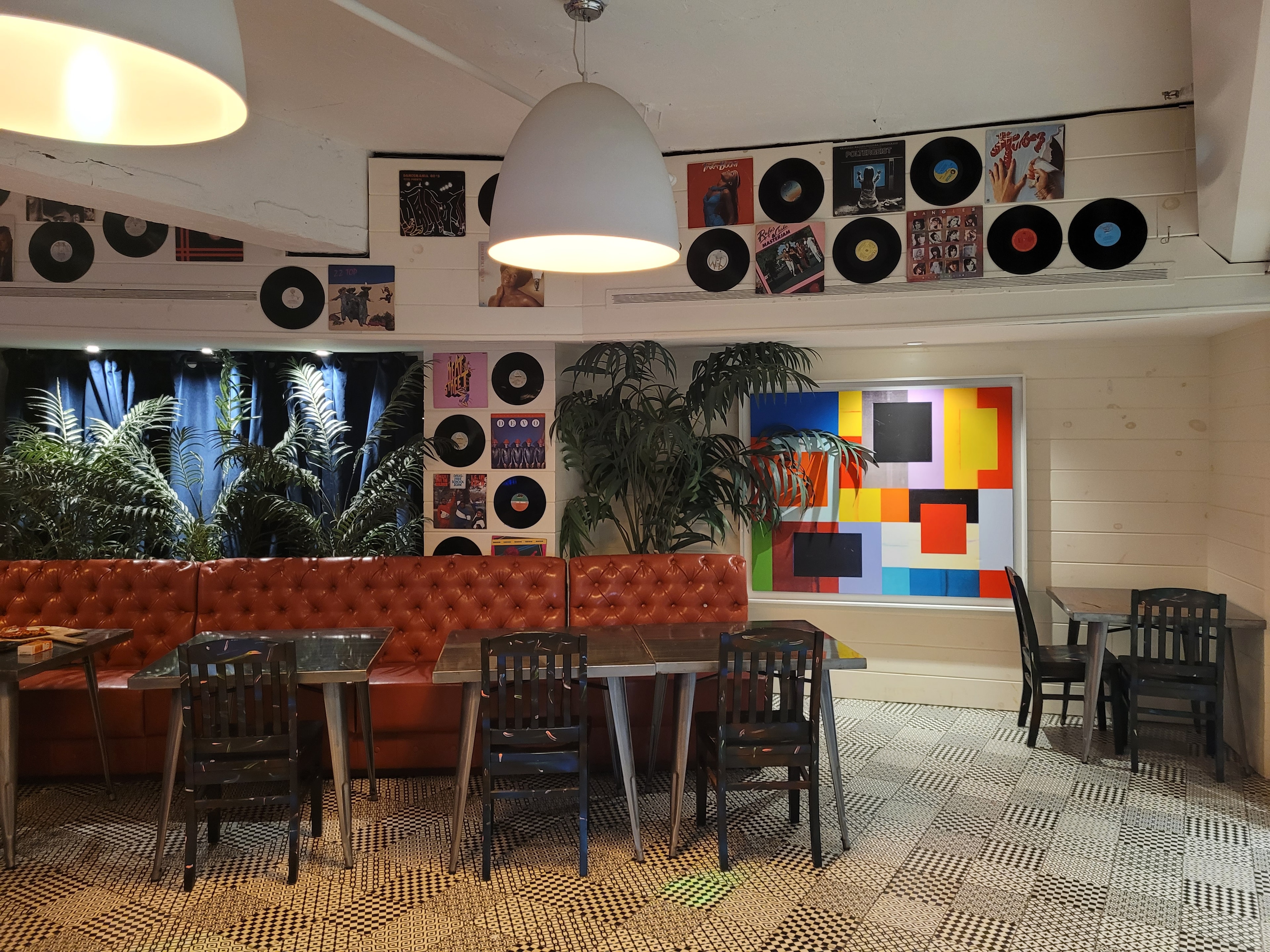 Rewind Pizzarama tufted leather banquet seating with colorful geometric mural and record wall art