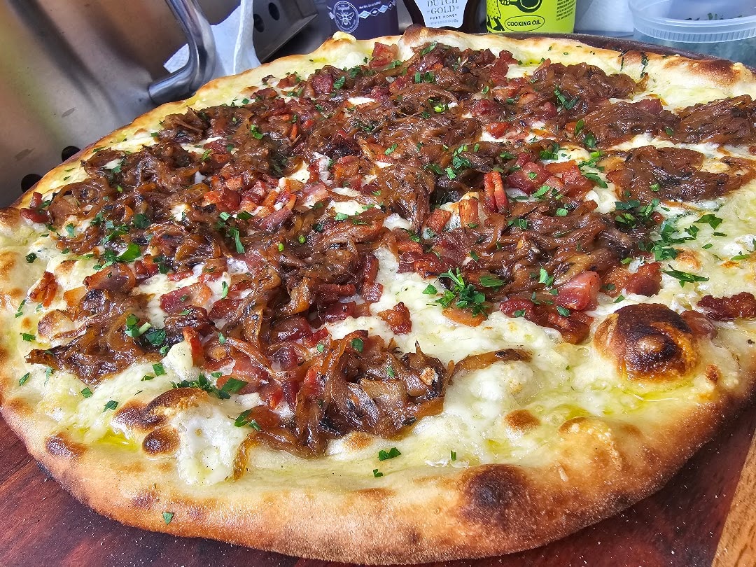Loaded meat pizza with fresh herbs