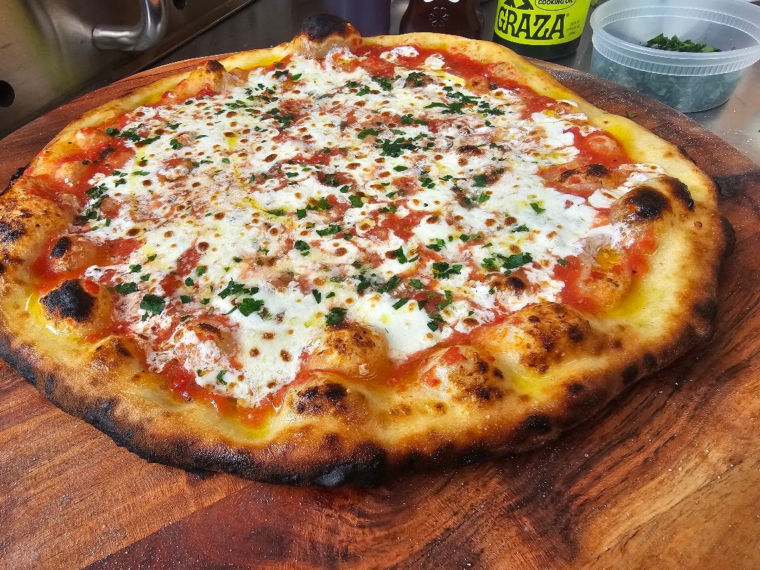 Wood-fired pizza with cheese and herbs