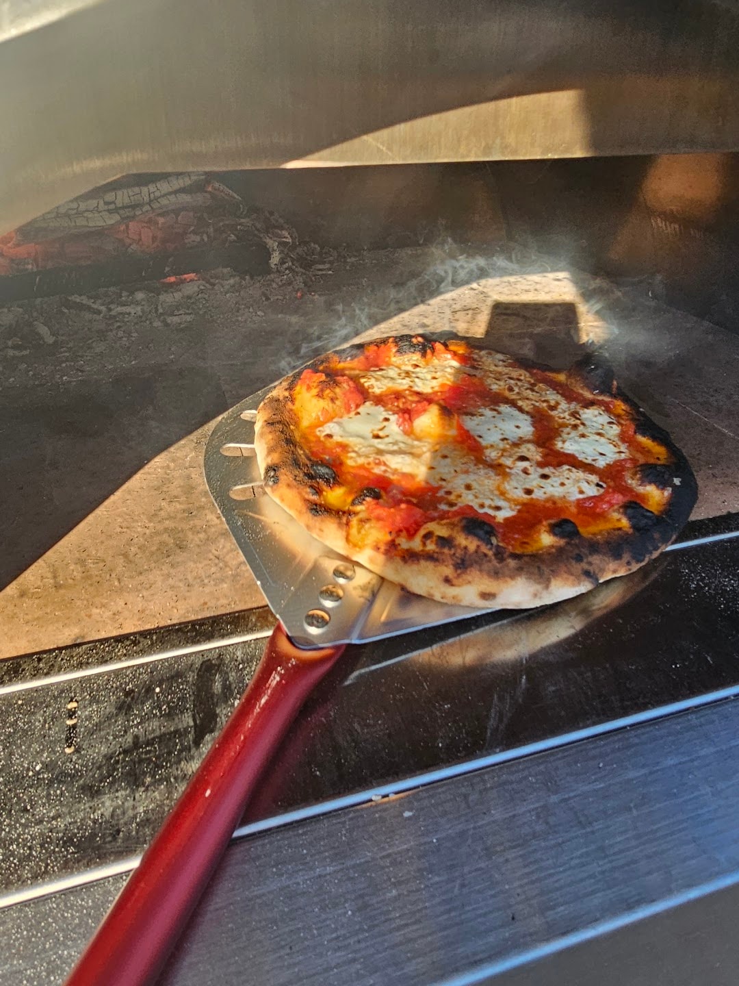 Pizza cooking in wood-fired oven